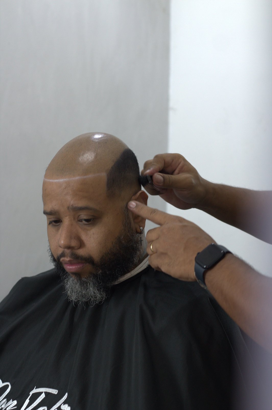 Julio Soares aplicando prótese capilar afro fio a fio